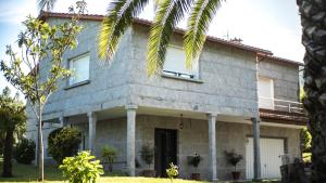 uma casa com uma palmeira em frente em Cotarenga em Campañó