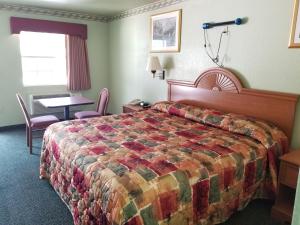 Habitación de hotel con cama, mesa y sillas en Haltom Inn Fort Worth en Fort Worth