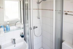 uma casa de banho com um chuveiro e um lavatório. em Hotel Jess am Meer em Büsum