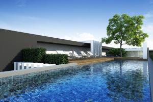 a swimming pool in front of a building at The September Salaya in Salaya
