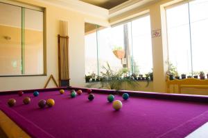 a purple pool table with balls on top of it at Hotel Casarão in Peruíbe