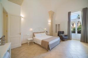 una camera con un letto e una sedia di Nuvole Barocche a Lecce
