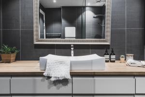 een badkamer met een witte wastafel en een spiegel bij Neumannsgate 4 in Bergen