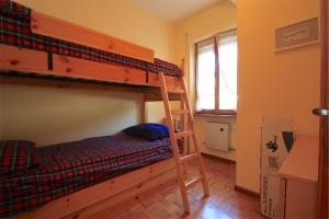 アウロンツォ・ディ・カドーレにあるAppartamento Panorama Dolomitiのベッドルーム1室(二段ベッド2台、窓付)が備わります。