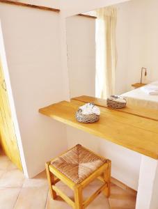 Habitación con mesa, cama y taburete en Votsalo Apartments, en Naousa