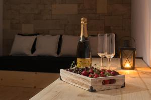 eine Flasche Champagner und eine Schachtel Erdbeeren auf dem Tisch in der Unterkunft Old Town Senses Boutique Hotel in Rhodos (Stadt)