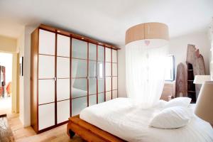 セビリアにあるUn Oasis en el Corazón de Sevillaのベッドルーム1室(ガラスの壁の白いベッド1台付)