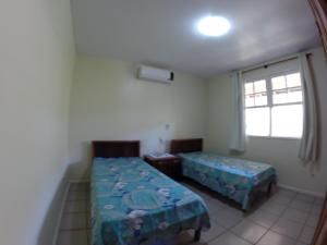 1 dormitorio con 2 camas y ventana en Casa na Lagoinha Florianópolis B1, en Florianópolis