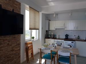 a kitchen with a table and chairs and a television at Biandada Apartments in Mamaia Sat/Năvodari +28 photos