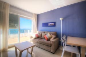 a living room with a couch and a large window at Apartamentos Playa Barbate in Barbate