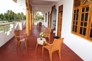 a balcony with chairs and a table with a vase of flowers at Nilaveli Star View Hotel in Nilaveli