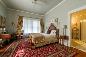 una camera con letto, scrivania e finestra di Historic Michabelle Inn a Hammond