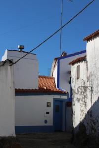 Vaiamonte的住宿－Casa Dos Livres，两座白色和蓝色的建筑,设有蓝色的门