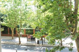 a park with trees and a bench and a sign at Hotel Italia in Ravenna