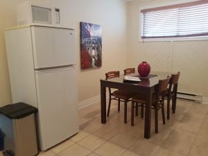 a kitchen with a table and a white refrigerator at 1-Bedroom Apartment Sweet #3 by Amazing Property Rentals in Gatineau