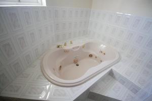 a bath tub in a room with white tiles at Sea View Chateau in Montego Bay