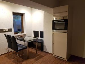 a small kitchen with a table and a refrigerator at Ferienhaus Waldblick in Sangerhausen