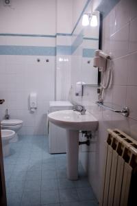 biała łazienka z umywalką i toaletą w obiekcie I love my House w Bolonii