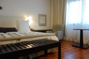 um quarto de hotel com uma cama e uma cadeira em Parador de Antequera em Antequera