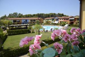 a view of a resort with a swimming pool and pink flowers at I Giardini Elisei in Policoro