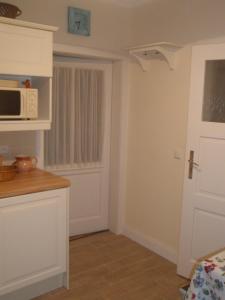 a kitchen with a white door and a microwave at Apartmán Nostalgie in Telč