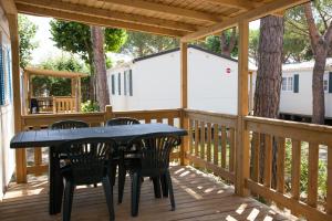 a patio with a table and chairs on a deck at Ca' Berton Village in Cavallino-Treporti