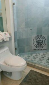 e bagno con servizi igienici e doccia in vetro. di Aqcua Condo Vallarta a Bucerías