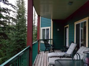 a porch with chairs and tables on a house at Vacation Homes by The Bulldog- Berker's Suite A in Silver Star