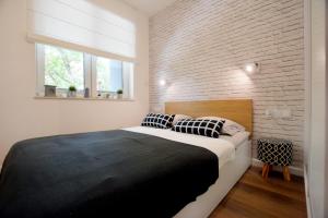 隱海市的住宿－Apartament 27 Dwie Sosny，一间卧室设有一张大床和砖墙
