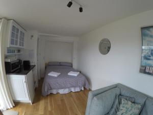 a small bedroom with a bed and a couch at The Retreat in Charmouth