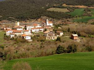 a group of houses on a hill with a green field at Elai Etxea Loft Baias in Pobes