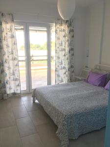 a bedroom with a bed and sliding glass doors at Aneta's Beach House in Vlorë +57 photos