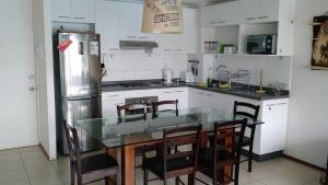 cocina con mesa, sillas y nevera en Apartamento Papudo Laguna 511B, en Papudo