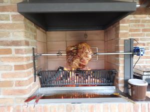 uma galinha está a ser cozinhada numa grelha em Penzion Prefila em Bulhary