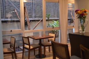 a dining room with a table and chairs and windows at Telmho Hotel Boutique in Buenos Aires