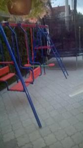a playground with blue and red swings at Apartments Lukić in Soko Banja