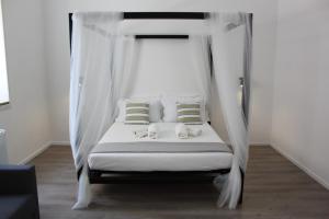 a bed with a canopy in a bedroom at Dimora di Artemide in Siracusa