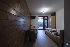 Un dormitorio con una gran pared de madera y una cama en Domek Na Fali, en Krynica Morska