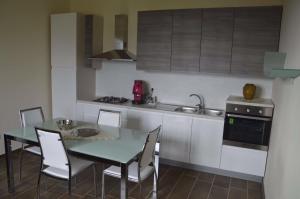 Una cocina con una mesa y sillas y un fregadero. en Il Piccolo Principe, en Cairano