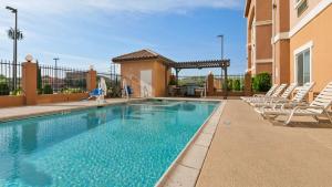 uma piscina com espreguiçadeiras ao lado de um edifício em Best Western Sonora Inn & Suites em Nogales