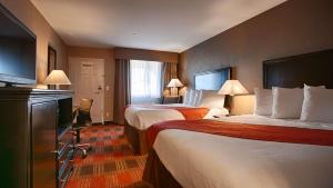 um quarto de hotel com duas camas e uma televisão em Best Western Willows Inn em Willows