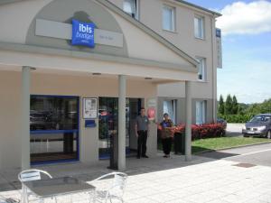 a man and a woman standing outside of a building at ibis budget Bar le Duc in Bar-le-Duc