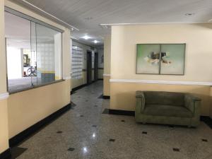 a waiting room with a chair in a building at Apartamento Pitangueiras in Guarujá