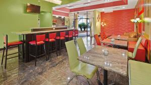 un restaurante con paredes rojas y verdes, mesas y sillas en Best Western Executive Inn, en Cairo