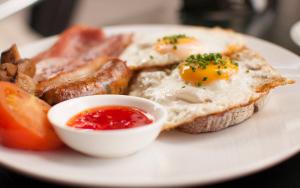 コロリにあるコロリ ビーチ リゾートの卵トースト、ベーコンを含む朝食用の食品