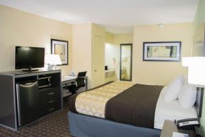 a hotel room with a bed and a desk at Best Western Coachlight in Rolla