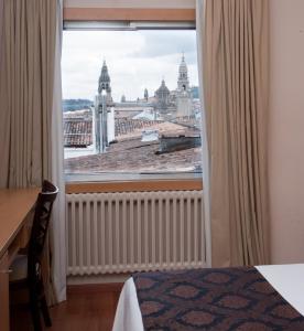 a hotel room with a large window overlooking a city at Hotel Universal in Santiago de Compostela