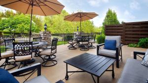 un patio con mesas, sillas y sombrillas en Best Western Plus Washington Hotel, en Washington