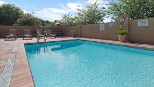 una gran piscina con sillas y una valla en Best Western Plus Goliad Inn & Suites, en Goliad