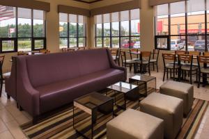 a living room with a couch and tables and windows at Best Western Ambassador Inn & Suites in Wisconsin Dells